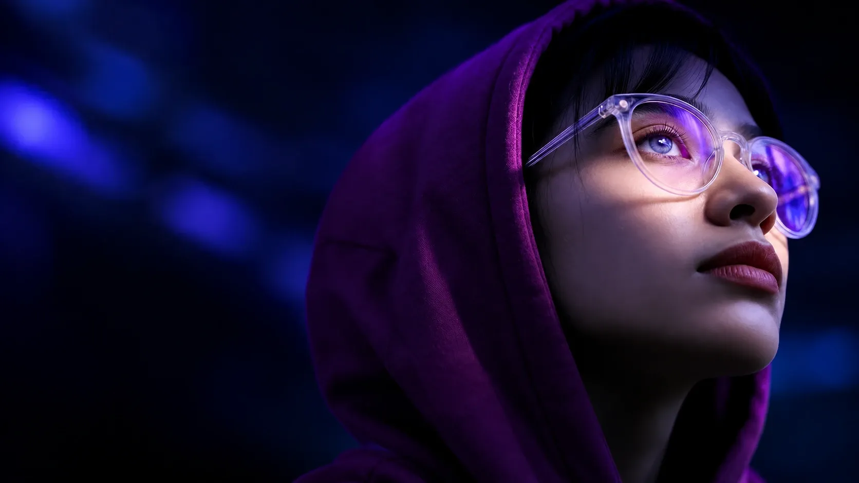 Persona con capucha violeta y gafas transparentes mirando hacia arriba